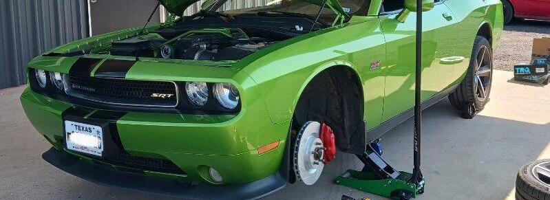 Green Challenger on jack stands for brake service